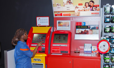 Print-Shop Migros Mitarbeiterin am Fotoautomat Thumbnail